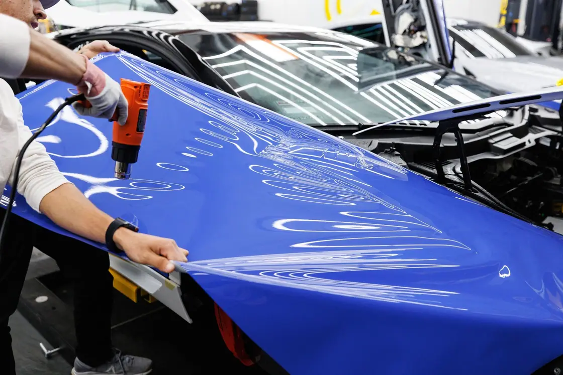 Working blue vinyl onto a hood photograph